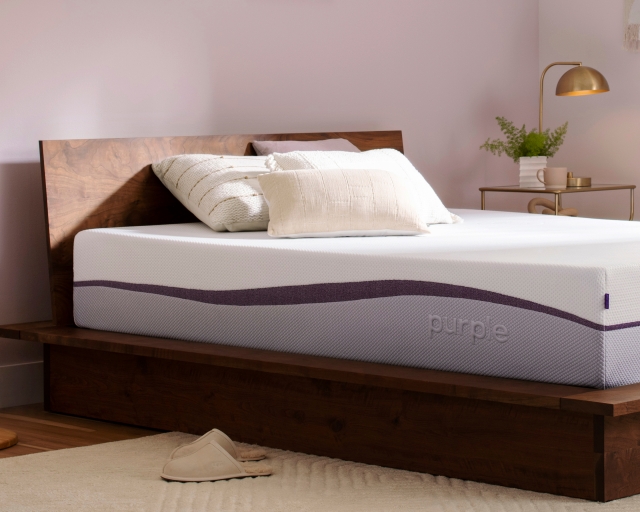 An unmade Purple Plus mattress in a bedroom