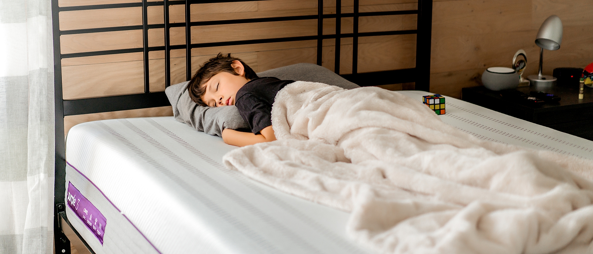 Young boy napping on a Purple Mattress and Pillow