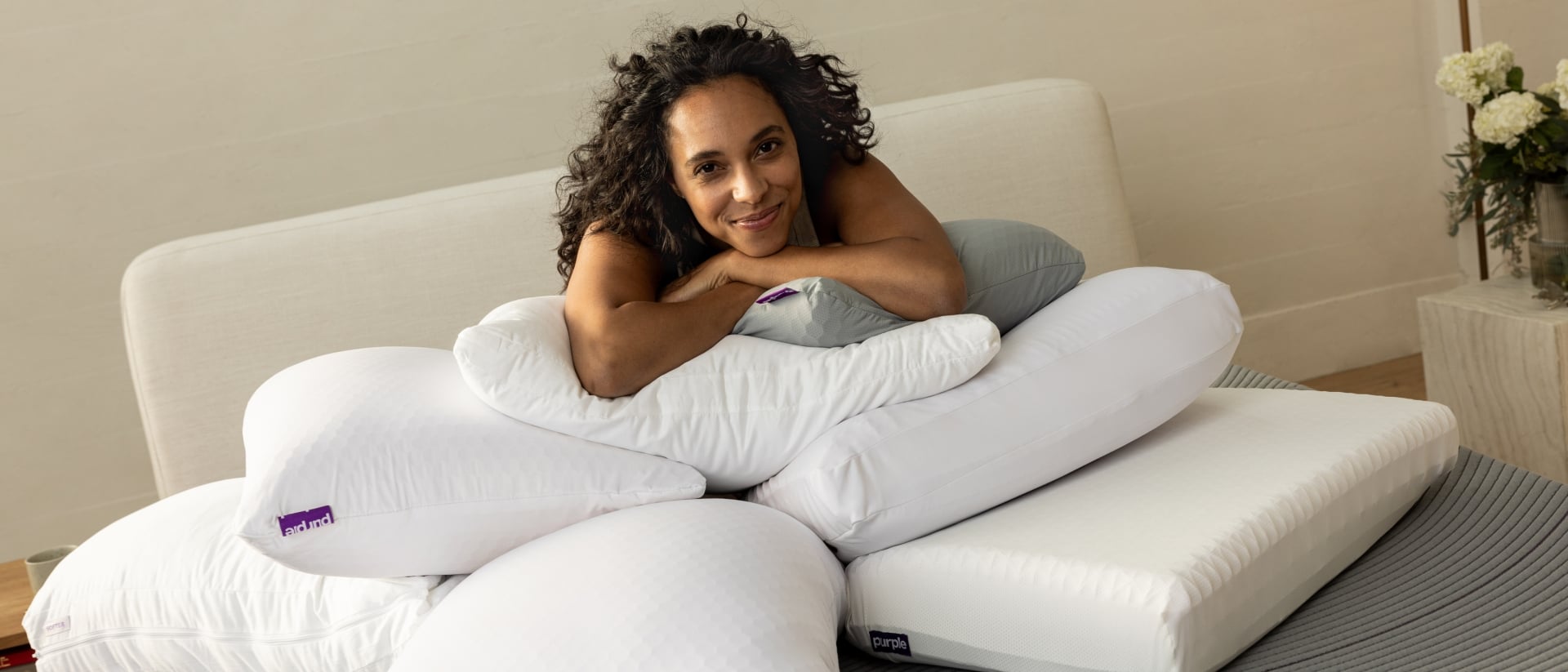 A woman lying on a pile of different Purple pillows